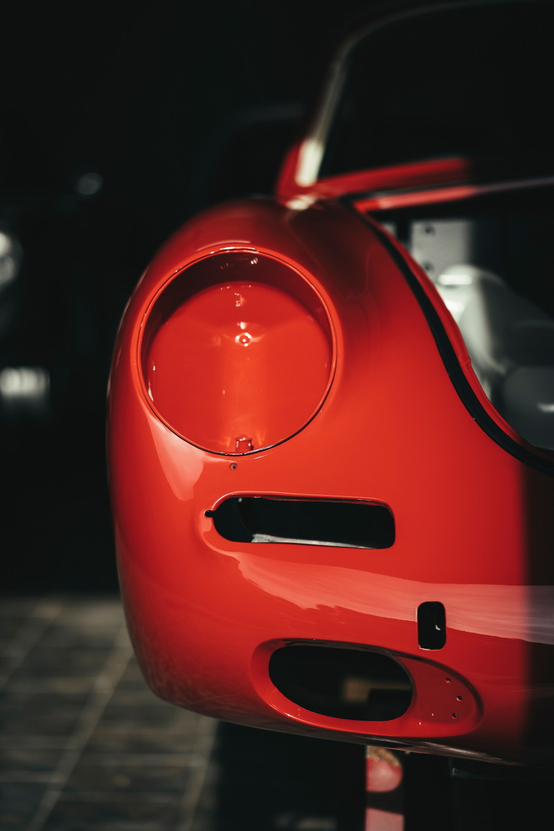 Vintage Rosso Corsa Ferrari 250 GTO body panel showing open headlight bucket, brake cooling ducts & front fascia details.