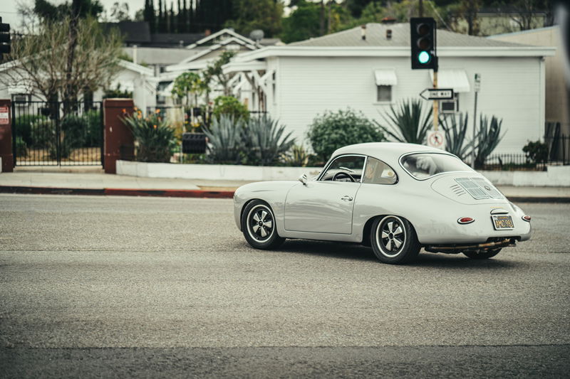 Light grey Porsche 356 outlaw coupe with black Fuchs-style rims, lowered stance in LA.