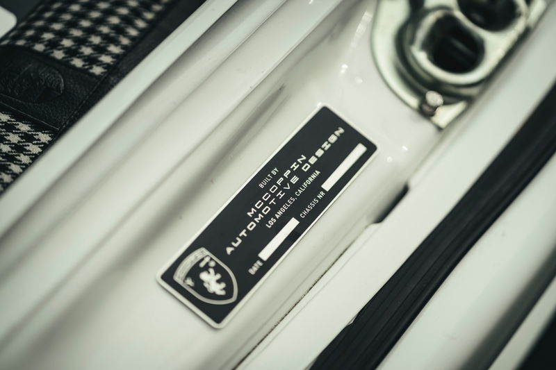 Custom white Porsche 911 by McCoppin Automotive Design. Close-up of door jamb builder's plate & houndstooth interior upholstery.
