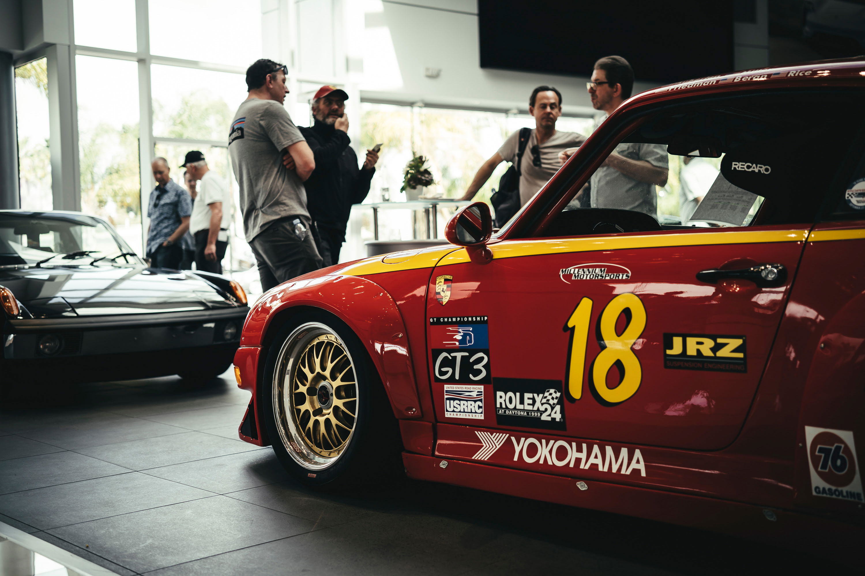 Red widebody Porsche 993 race car with #18 GT3 livery, Yokohama decals, and gold multi-spoke rims.