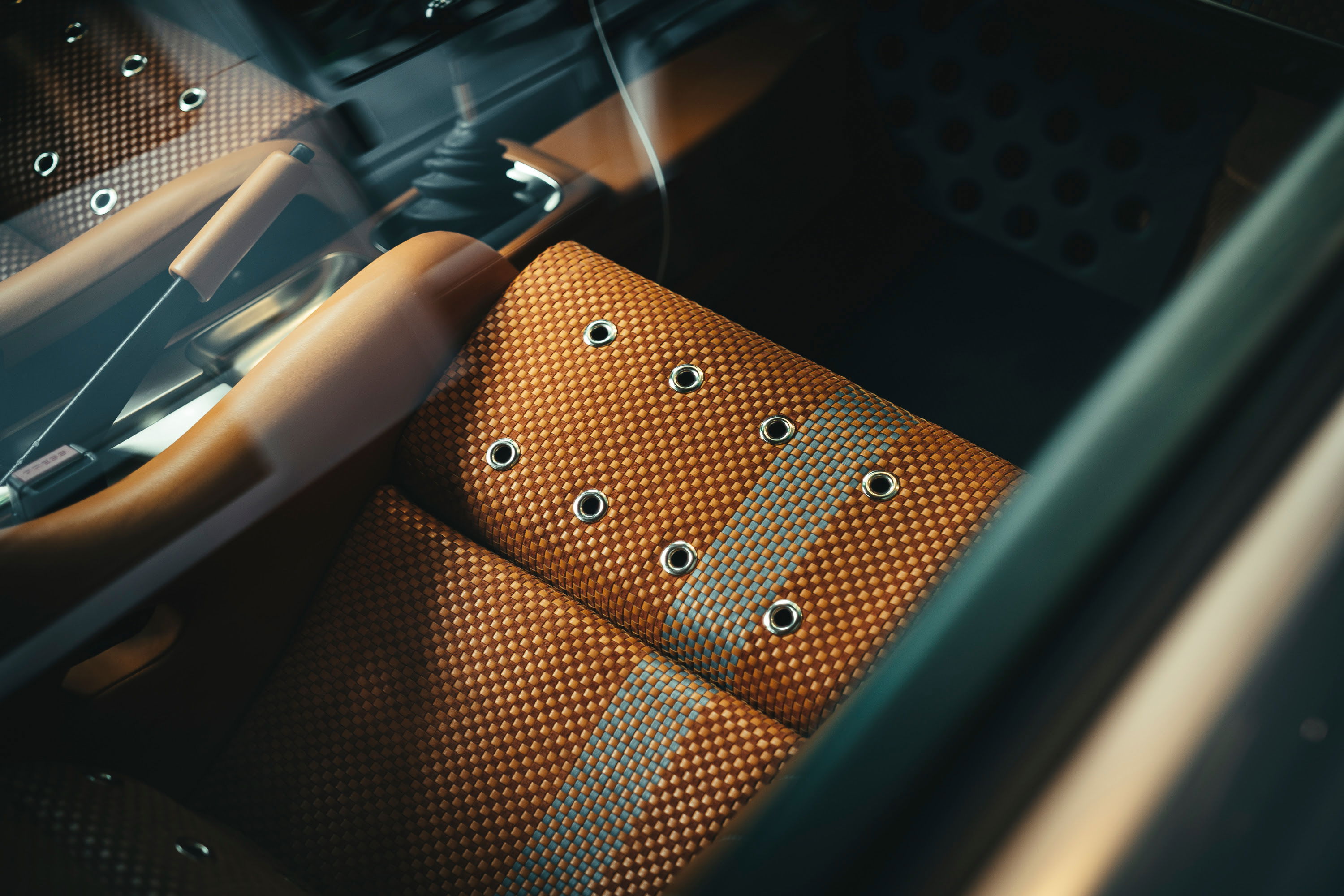 Air-cooled Porsche interior: bespoke orange woven seats with metal grommets, tan trim, and manual shifter. Luftgekühlt show.