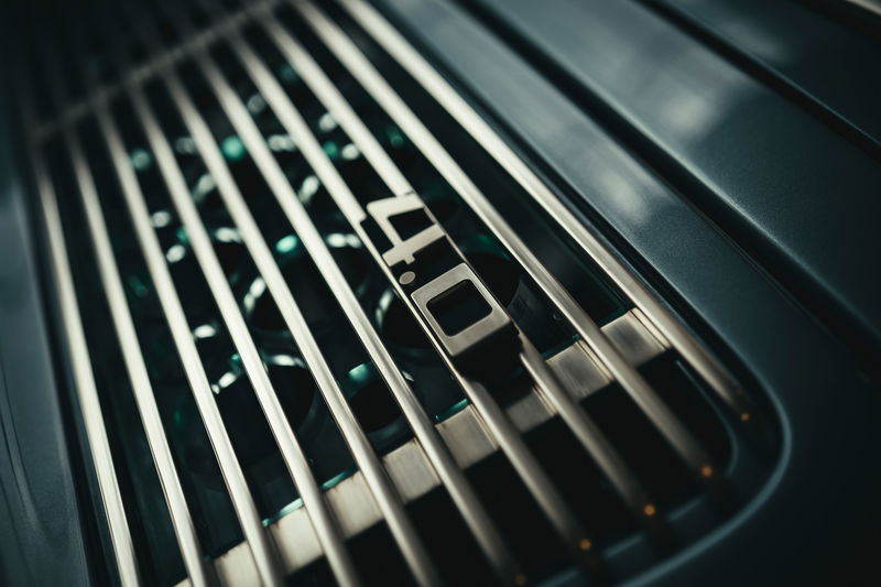Close-up of a dark green Porsche 911 GT3 RS 4.0's rear engine cover, featuring its iconic '4.0' badge and vent grille.