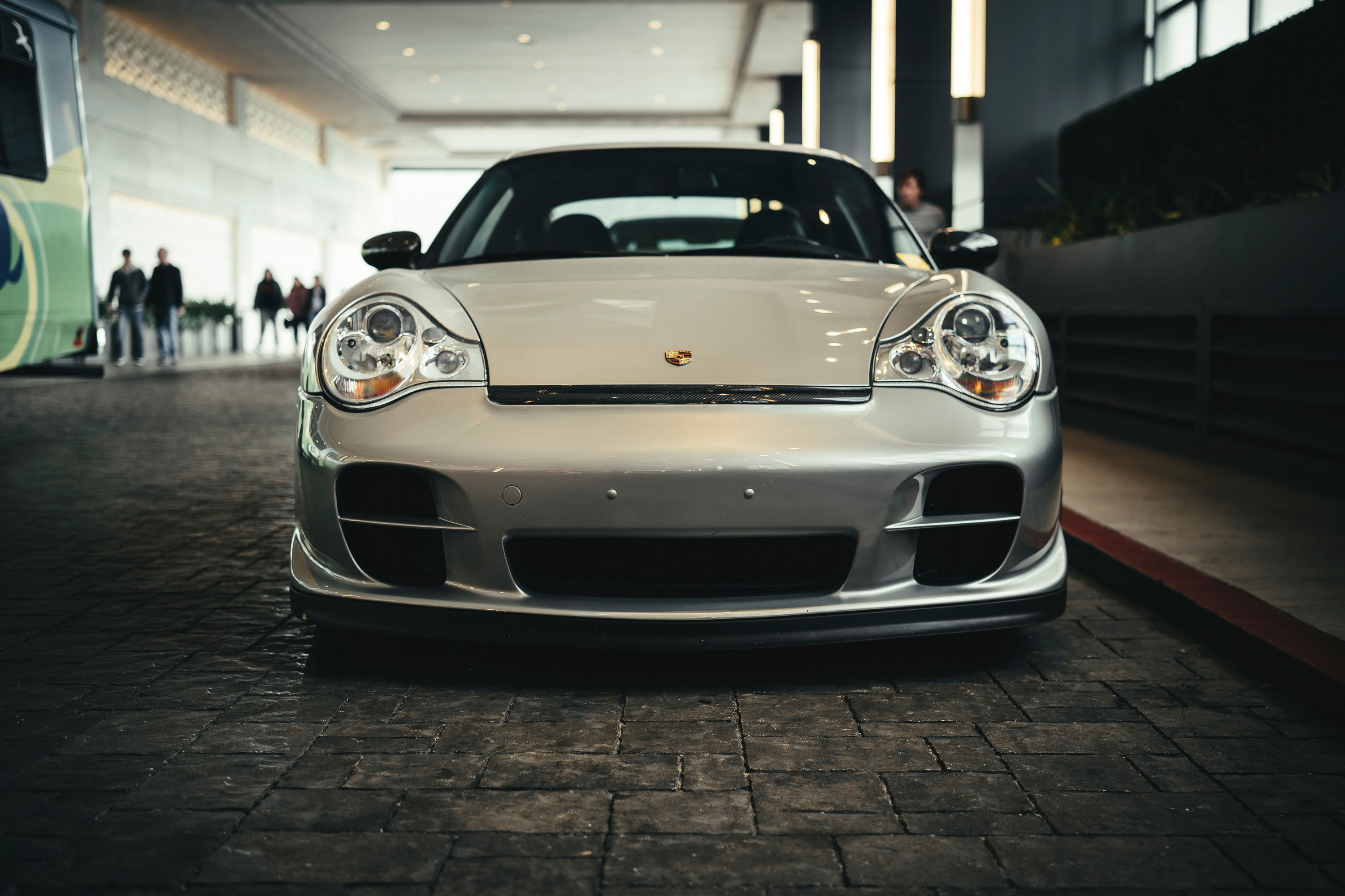 Silver Porsche 996 GT3, front view. Distinct "fried egg" headlights, aero bumper, and prominent lower splitter.