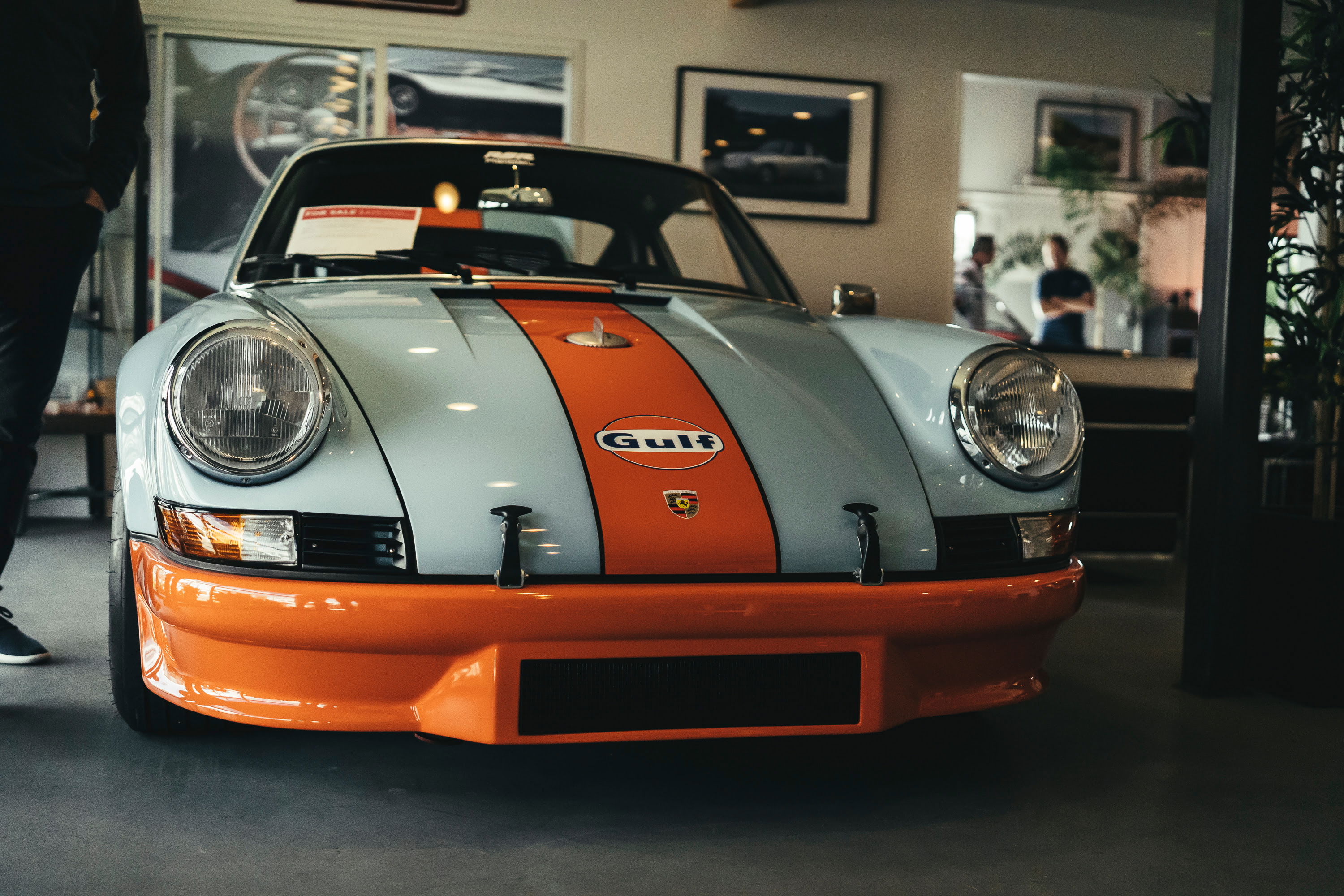 Iconic Gulf livery Porsche 911 RSR tribute: light blue paint, orange racing stripes, wide front bumper, exposed hood pins.