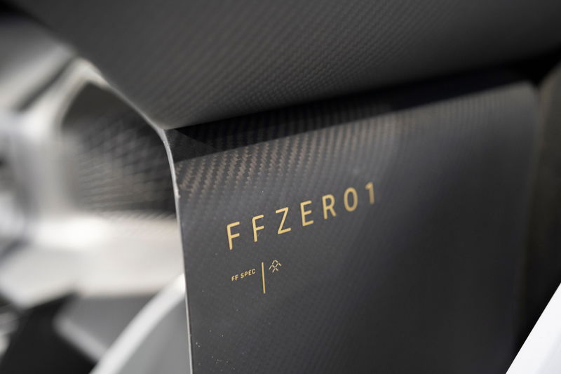 Faraday Future FFZERO1 concept's dark carbon fiber trim, featuring gold 'FFZERO1' branding and 'FF SPEC' detail.