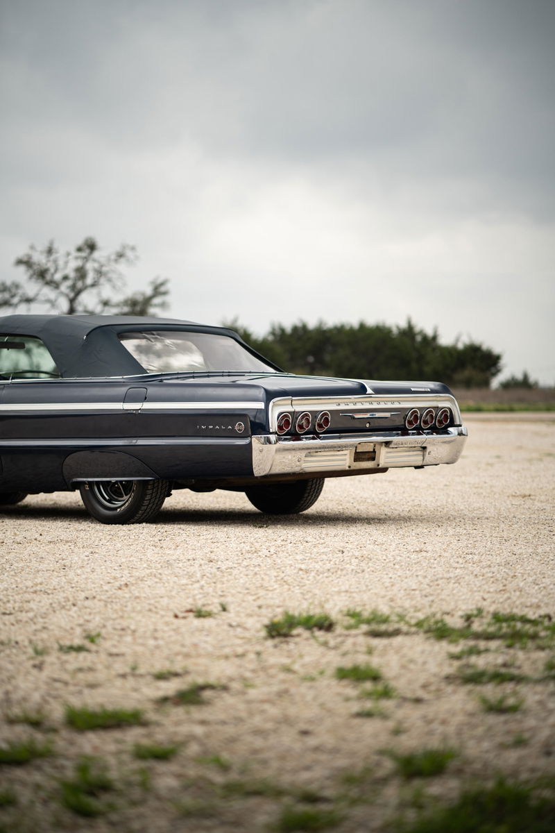 1964 Chevrolet Impala SS convertible in navy blue. Rear view showing chrome bumper & triple tail lights.