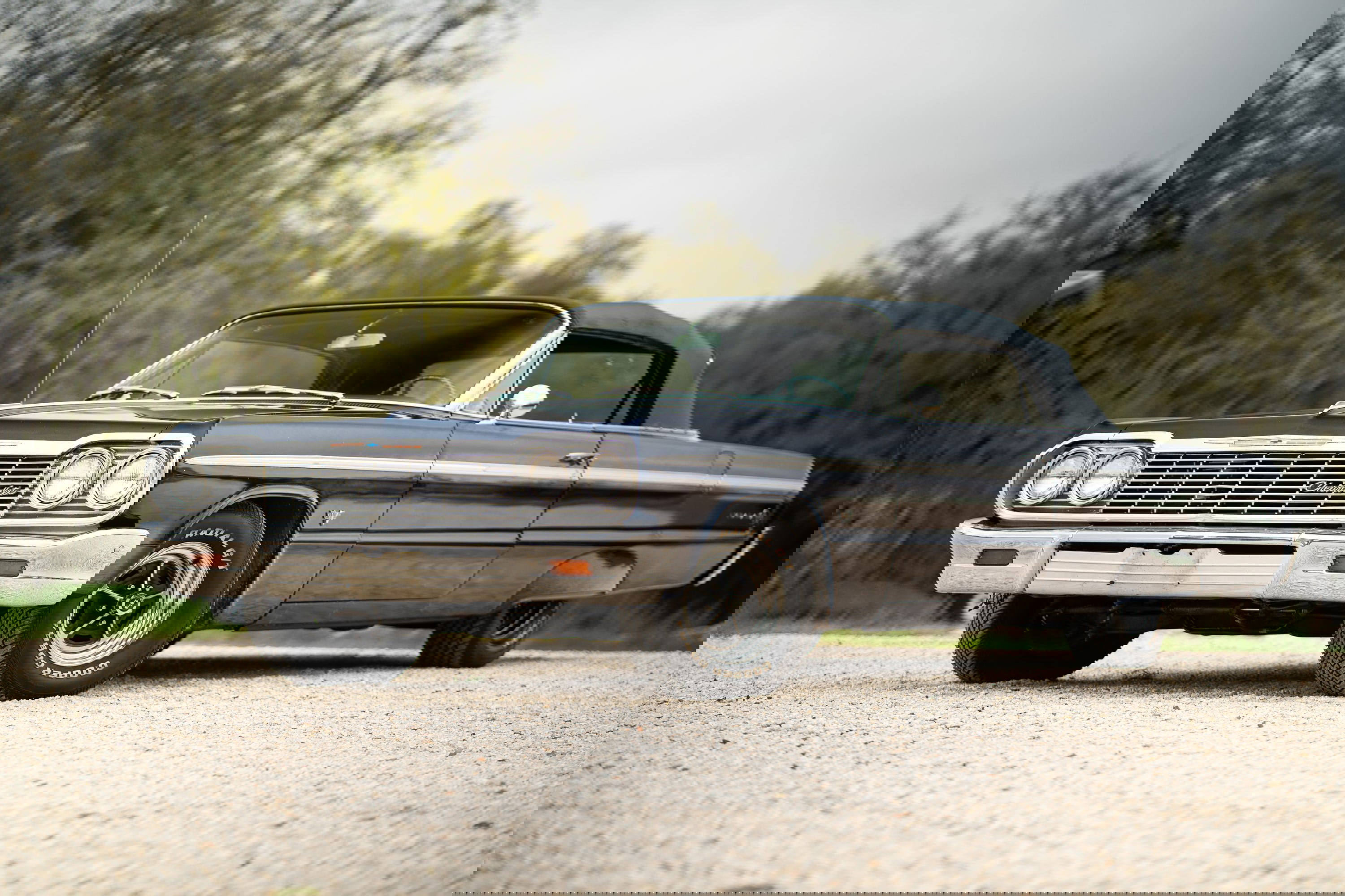 1964 Chevrolet Impala SS convertible in dark blue with chrome trim and classic rims.