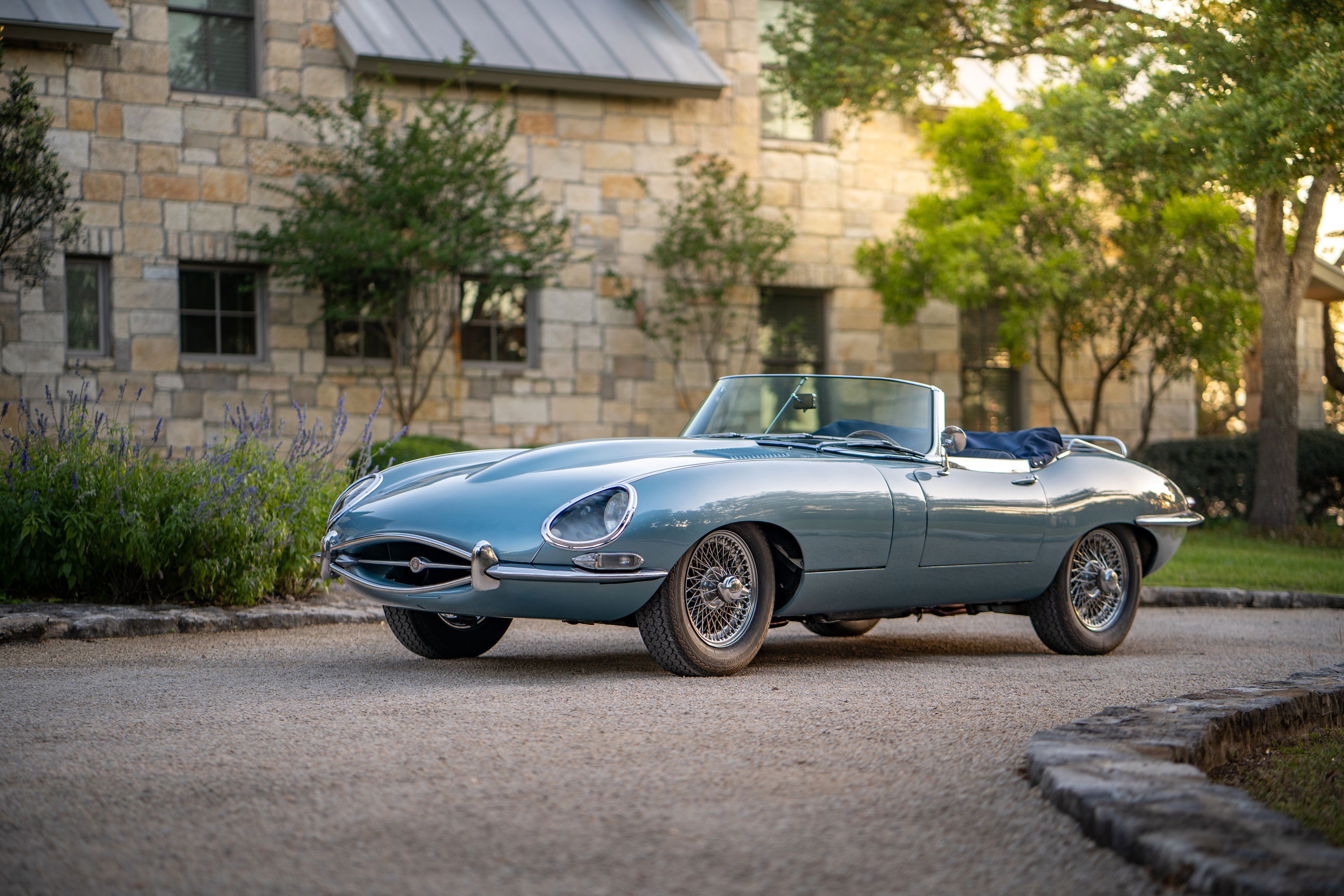 1966 Jaguar XKE convertible in opalescent silver-blue, featuring chrome wire rims and pristine body trim.