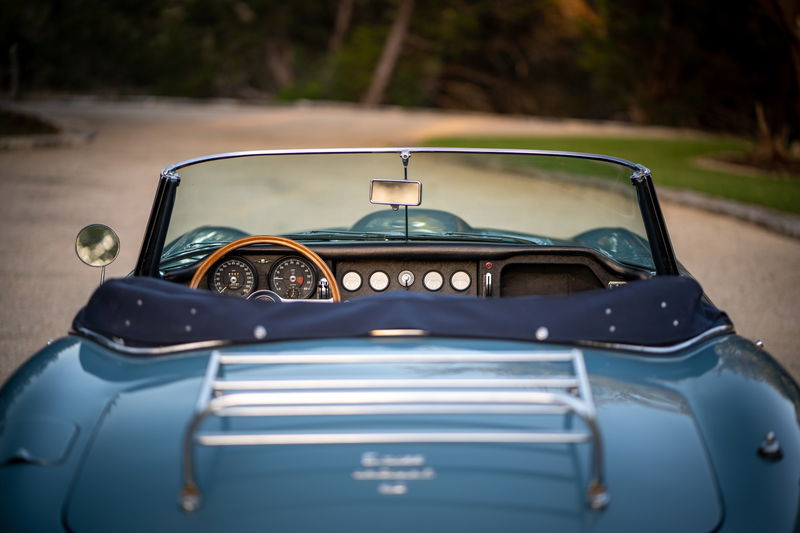 Opalescent silver-blue 1966 Jaguar XKE convertible interior and rear deck with luggage rack.