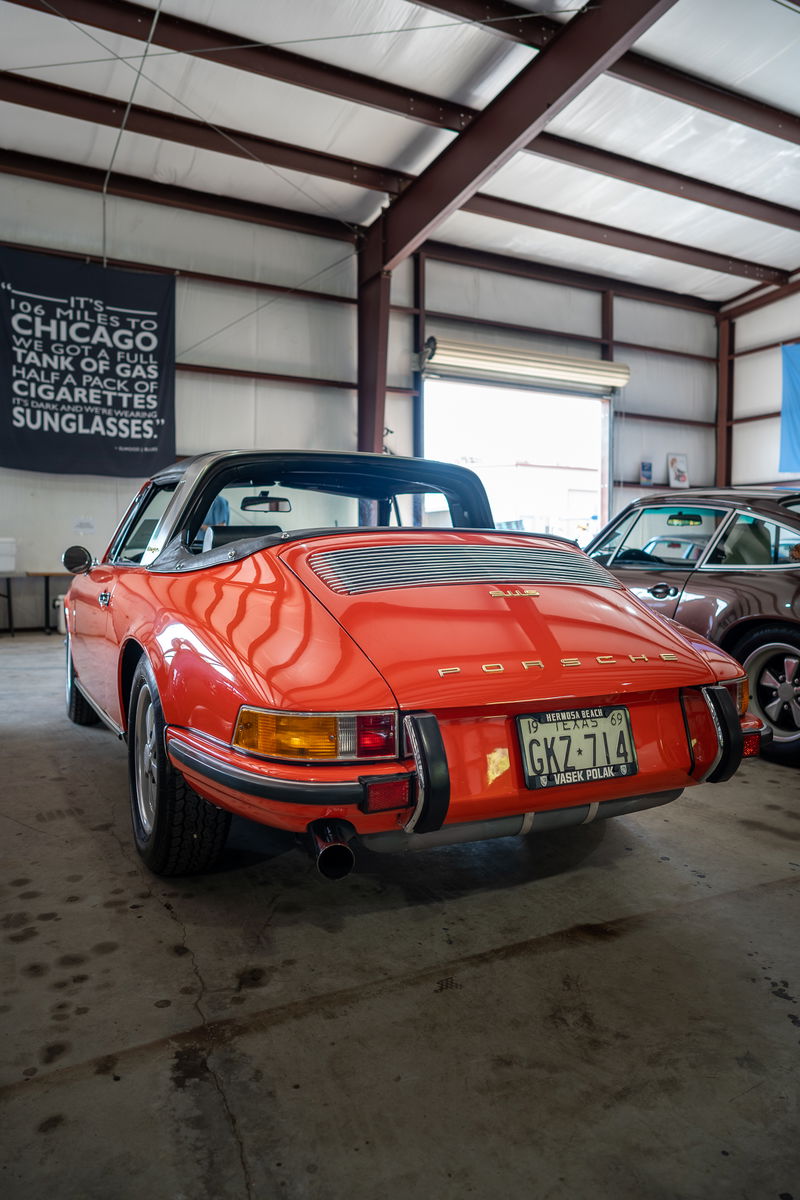 Rear view of a red 1969 Porsche 911 Targa in a garage.