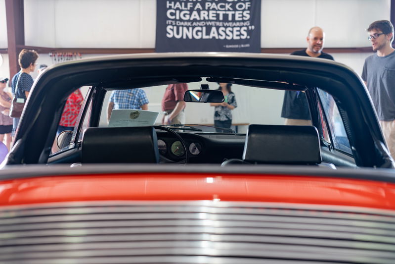 Interior rear view of a red Porsche Targa, showing dashboard and T-top headliner.