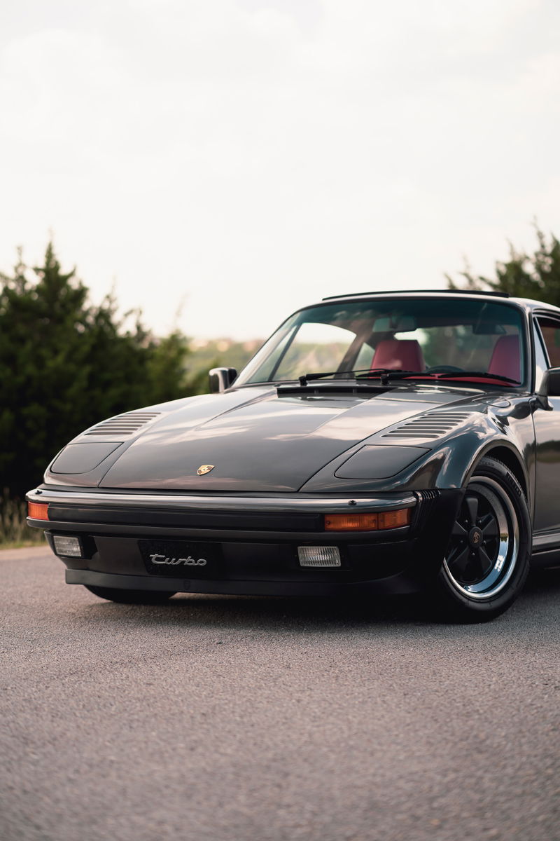 1989 Porsche 930 Turbo Flachbau with red interior and black Fuchs rims.