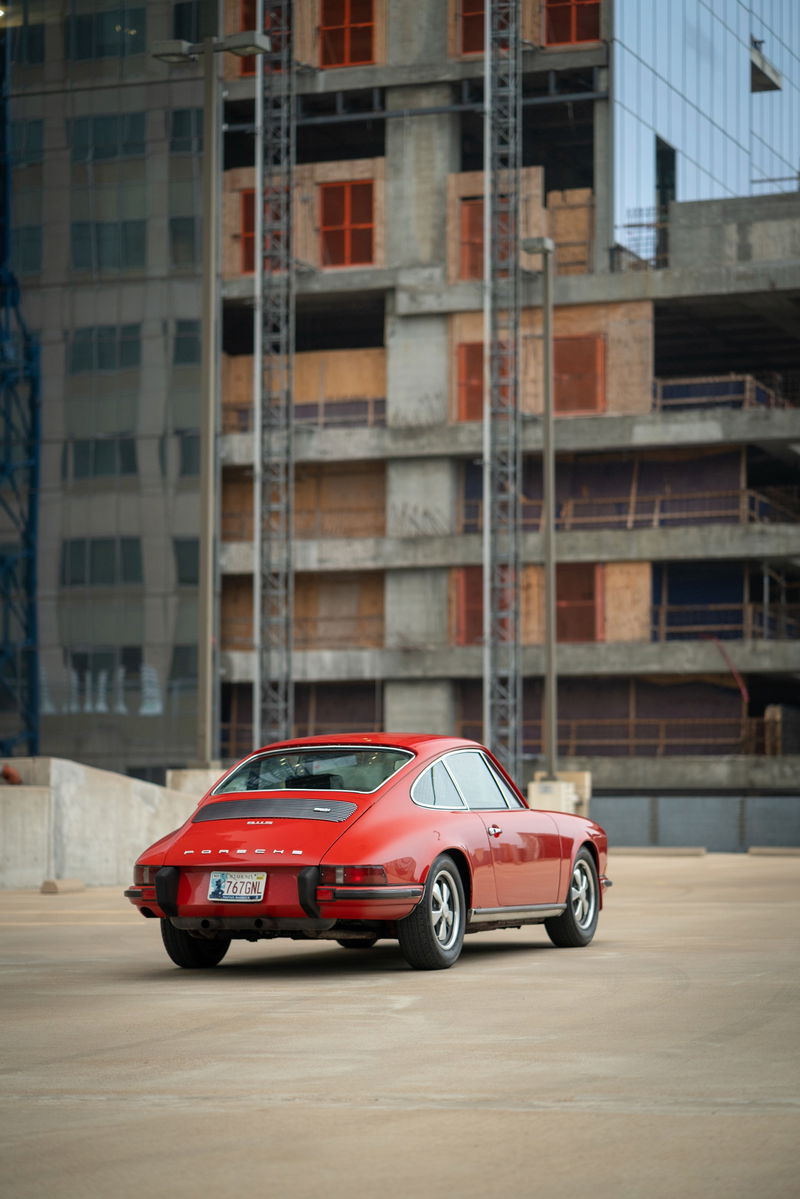 Red 1973 Porsche 911S rear view, showcasing its classic trim and silver rims.