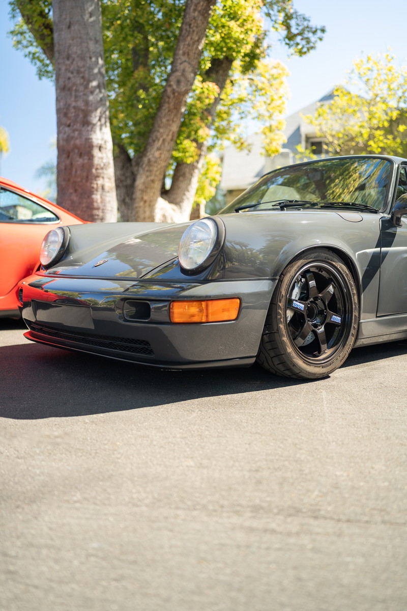 Gray Porsche 911 (964) with black TE37 rims, front view.