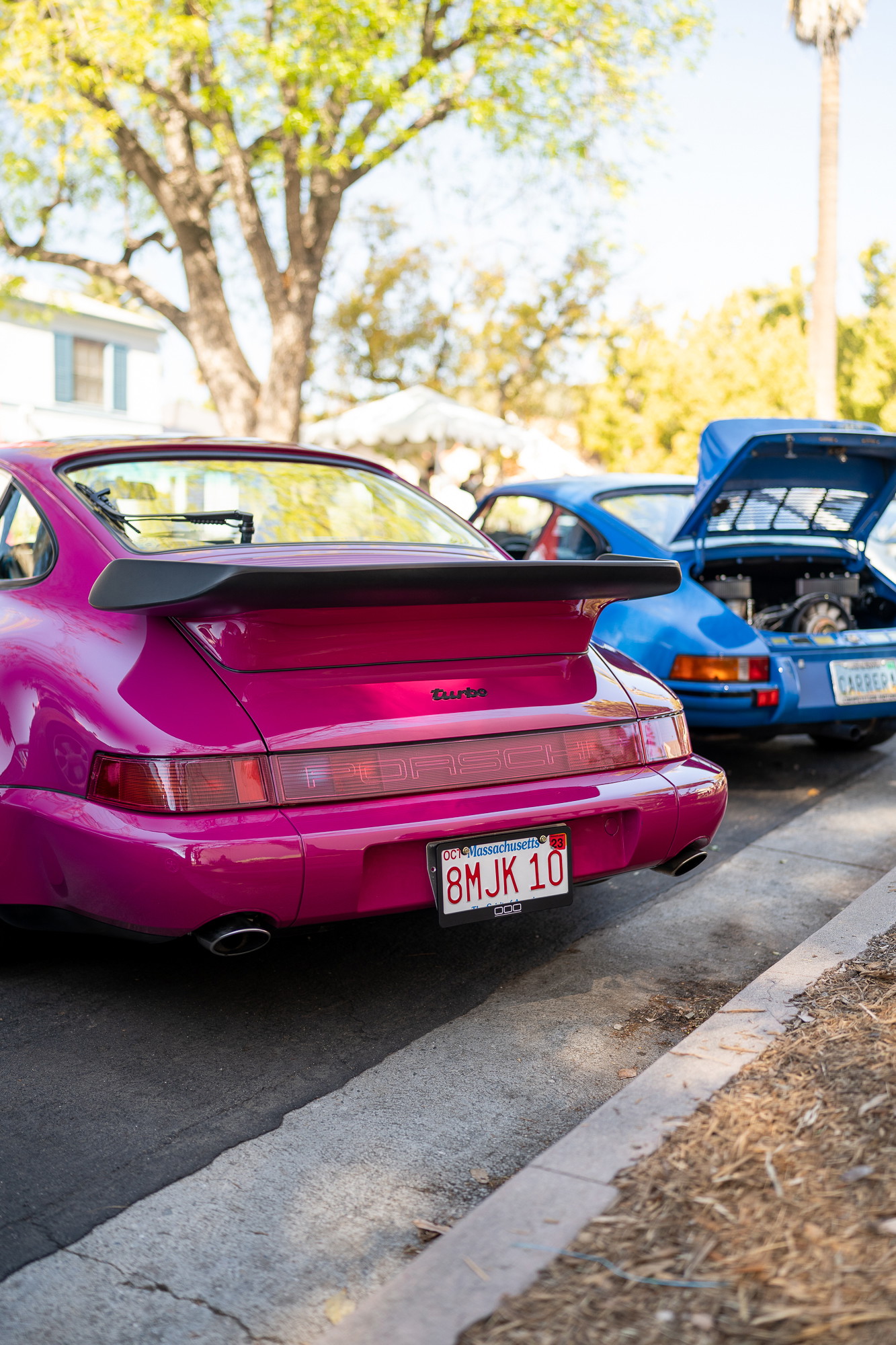Pink Porsche 911 Turbo with large spoiler. Blue Porsche Carrera behind it.