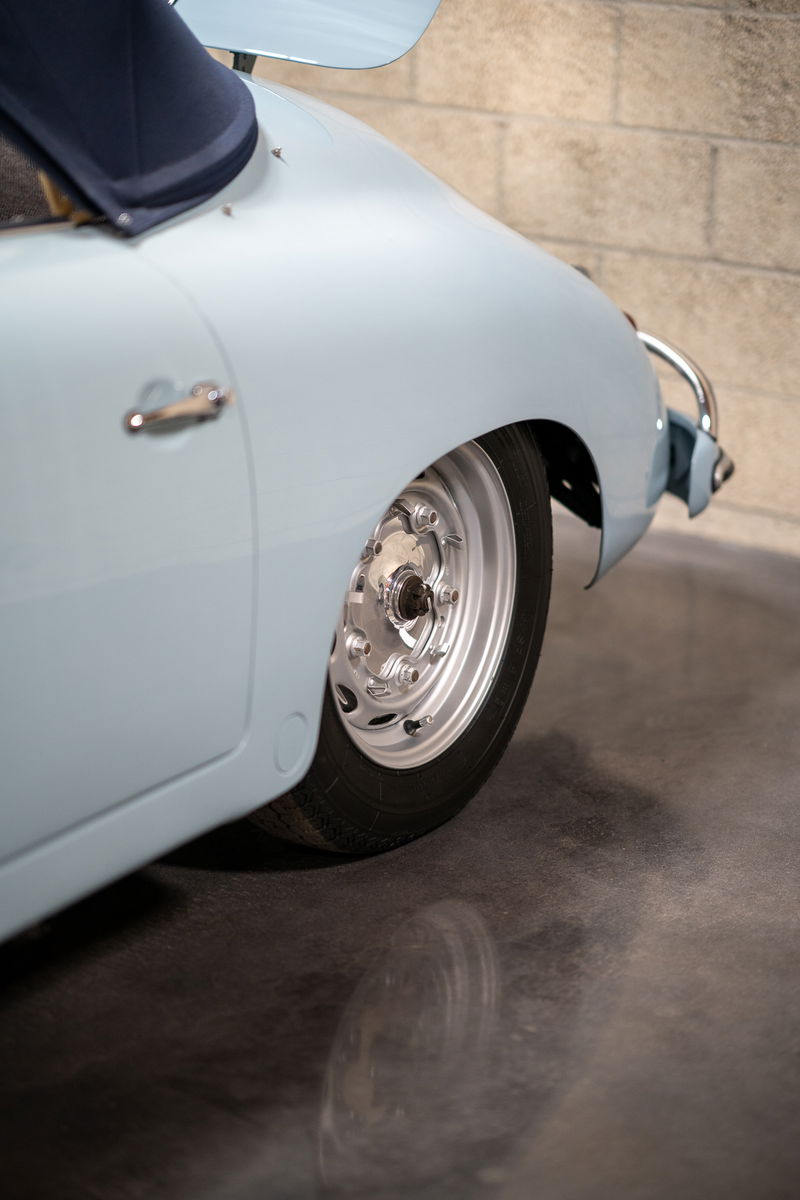 Light blue 1950s Porsche 356 Speedster rear wheel with polished aluminum rims.