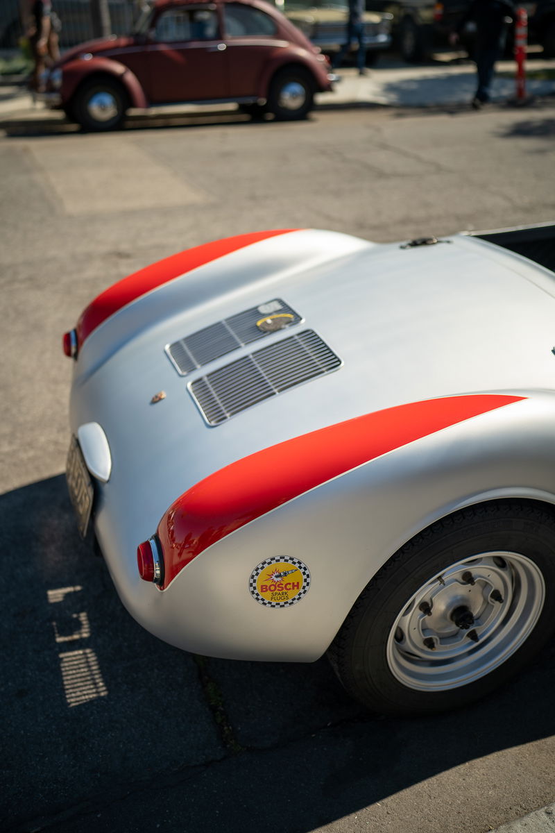 Close-up of a silver Porsche 550 Spyder with red trim and a Bosch decal on the fender.