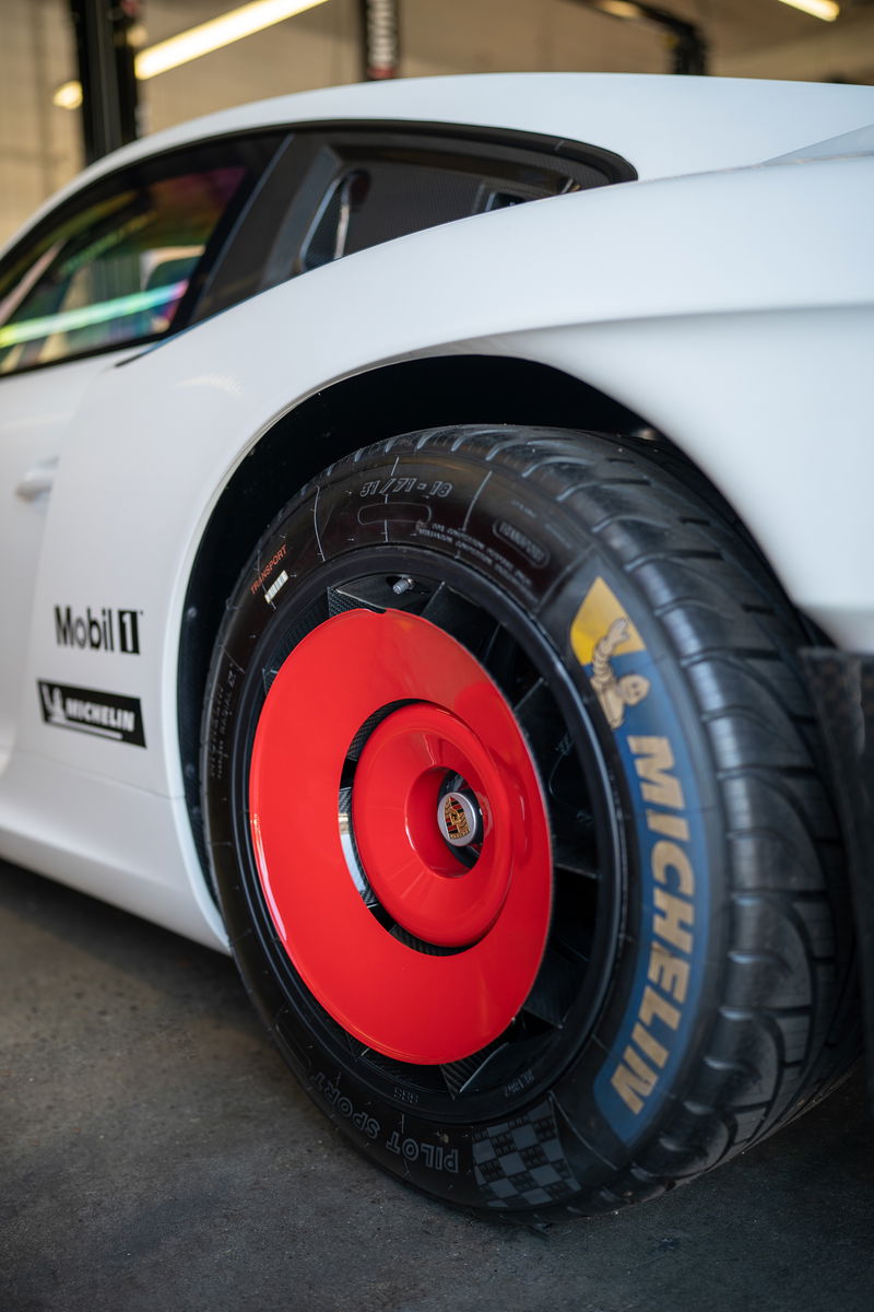 White Porsche 911 with red aero disc wheels and Michelin Pilot Sport tires.