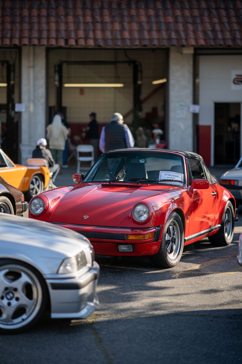 Red 1980s Porsche 911 Targa with black trim and Fuchs rims.