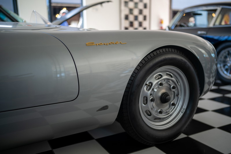 Silver Porsche 550 Spyder with gold badging and vintage steel rims.