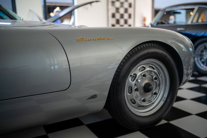 Silver Porsche 550 Spyder with gold badging and vintage steel rims.