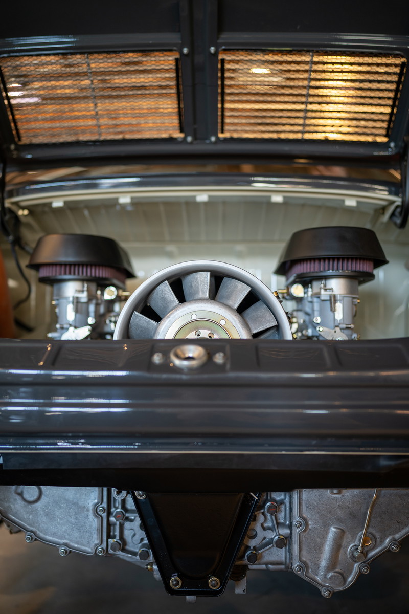 Porsche 911 engine bay with dual carburetors and cooling fan.