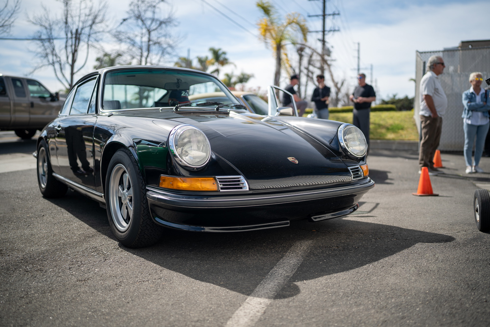 1970s Porsche 911 coupe in black, featuring chrome trim and classic rims.