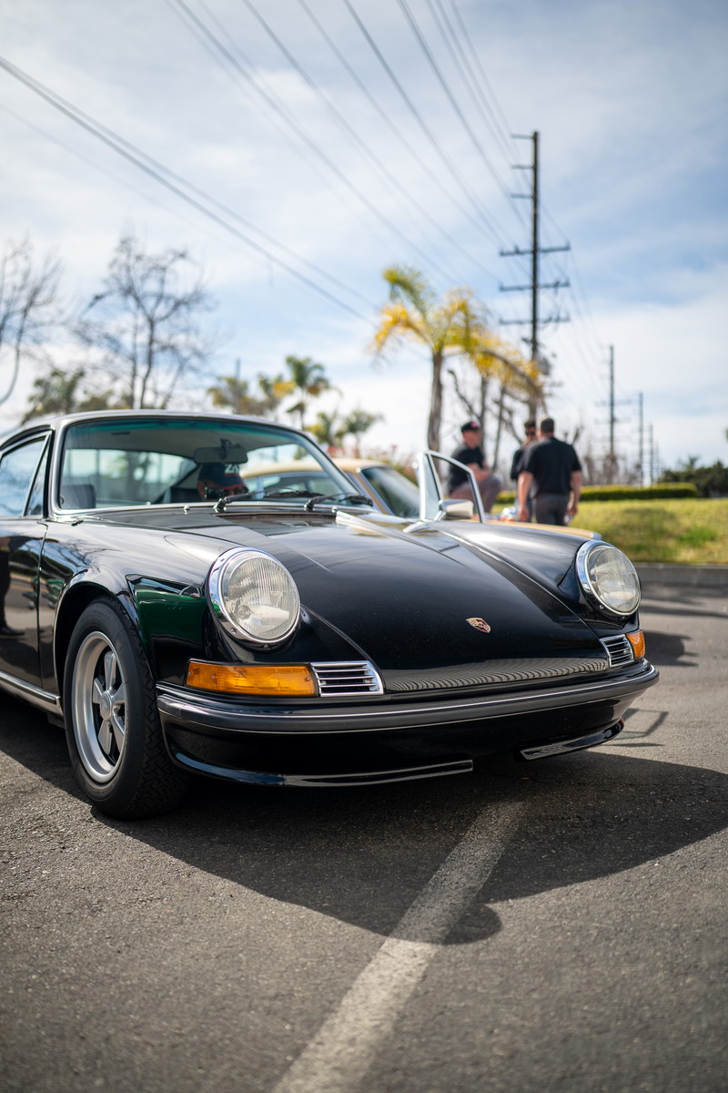 Black Porsche 911 with chrome trim and Fuchs rims.