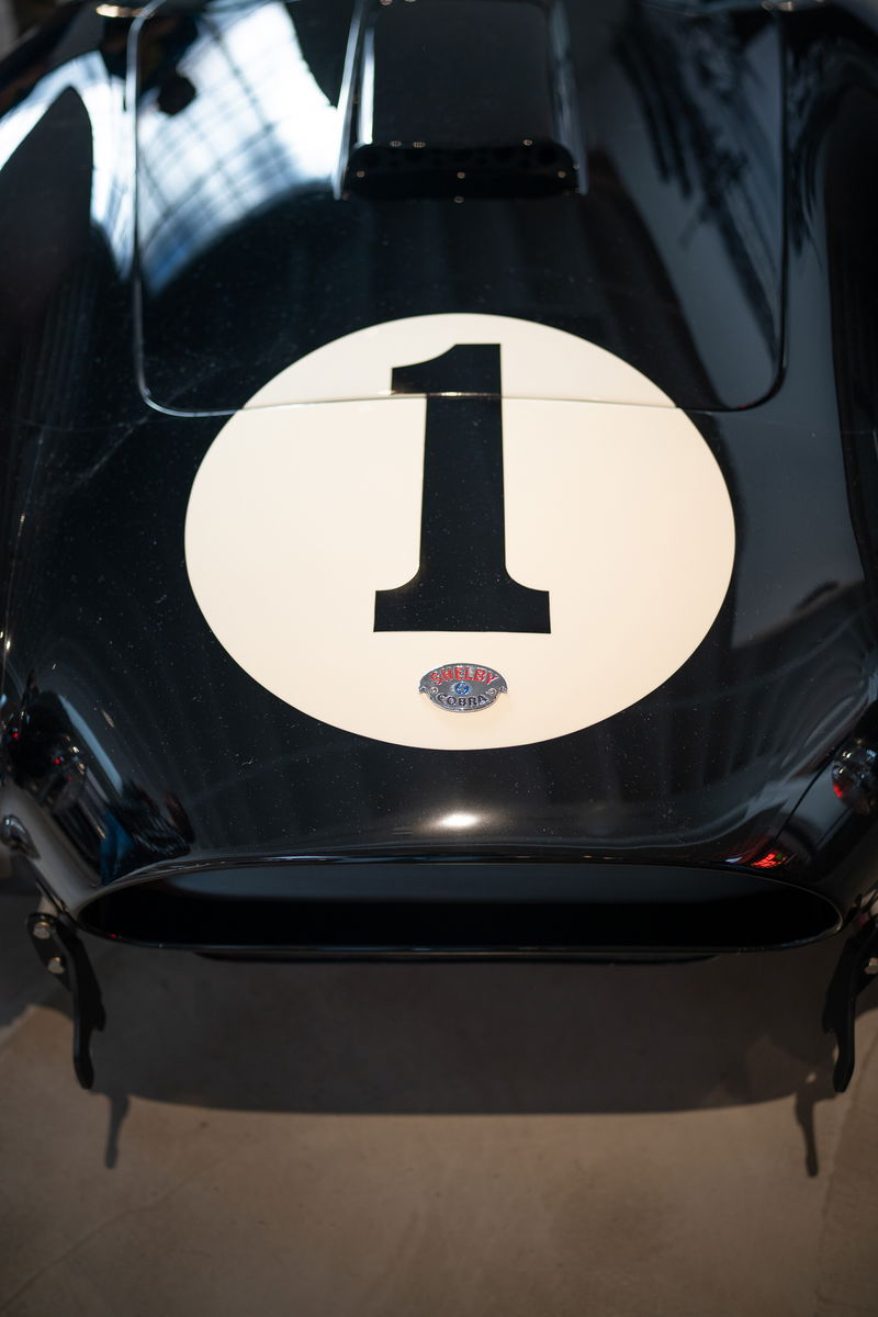 Black Shelby Cobra with white roundel #1 racing livery and chrome trim.