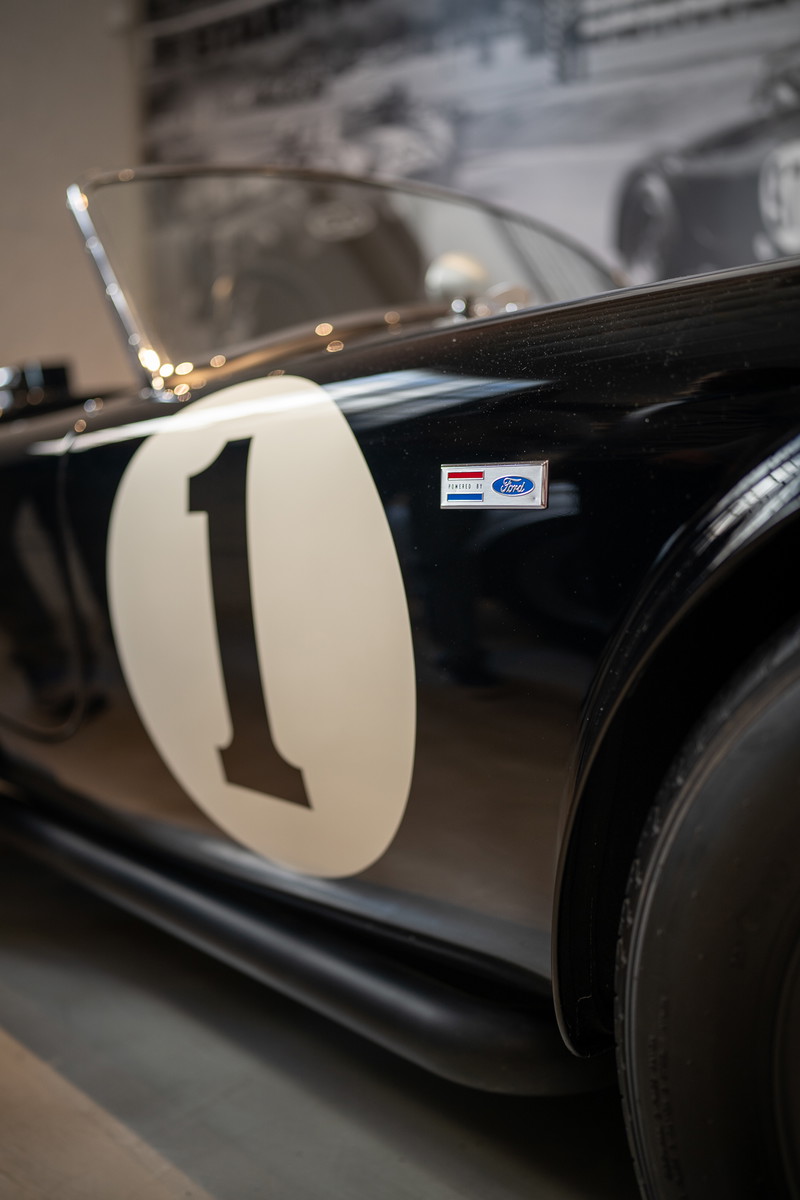 Black Ford Cobra race car with white #1 livery and Ford Powered badge.