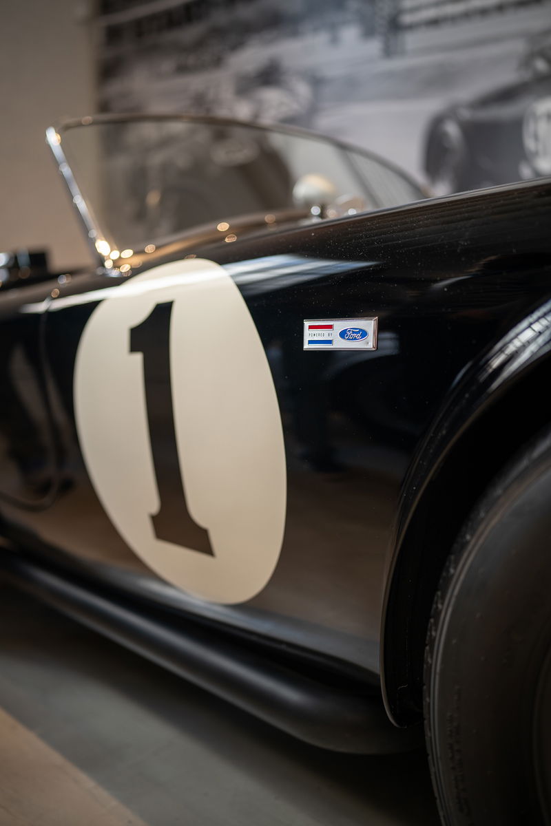 Black Ford Cobra race car with white #1 livery and Ford Powered badge.
