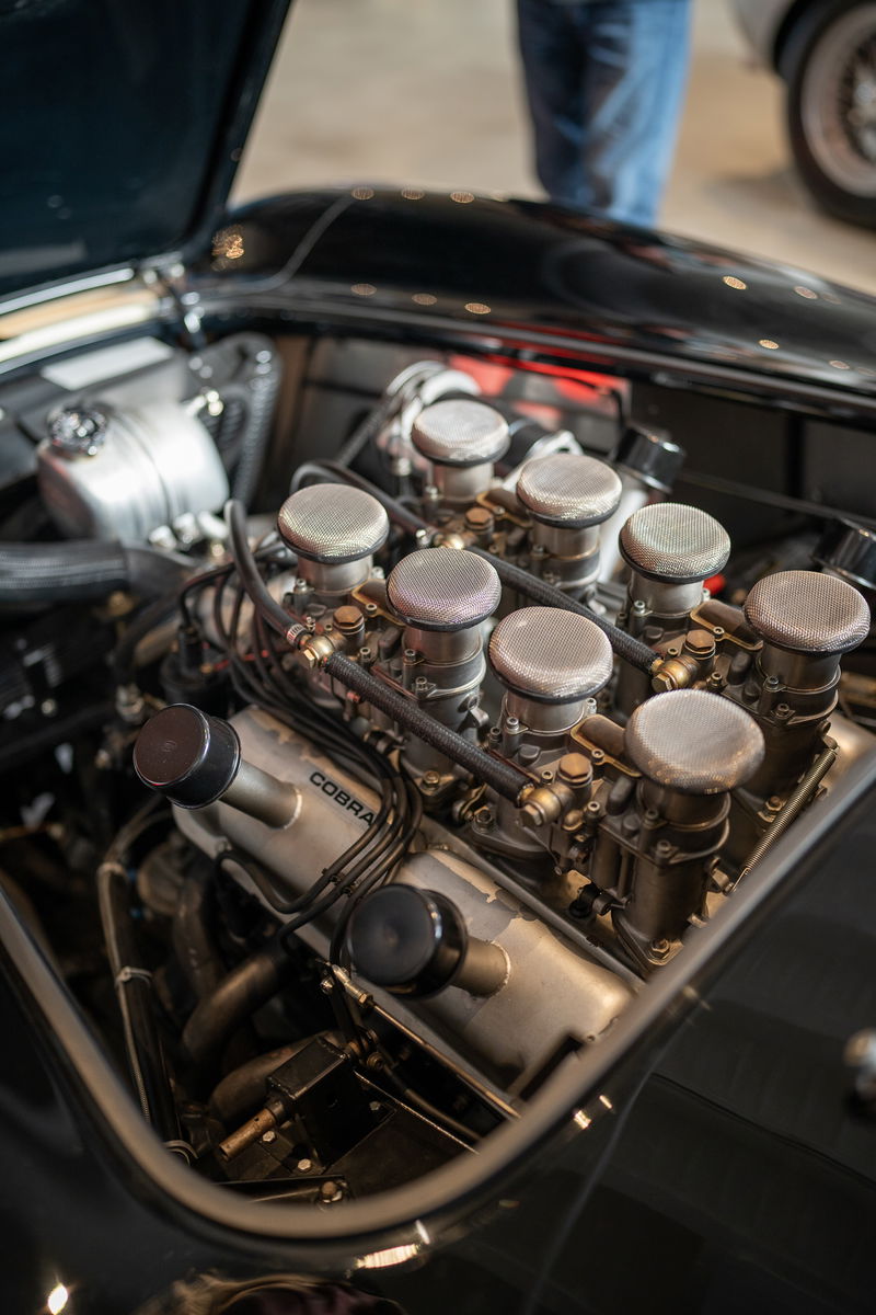 Black Cobra V8 engine with Weber carburetors and velocity stacks.