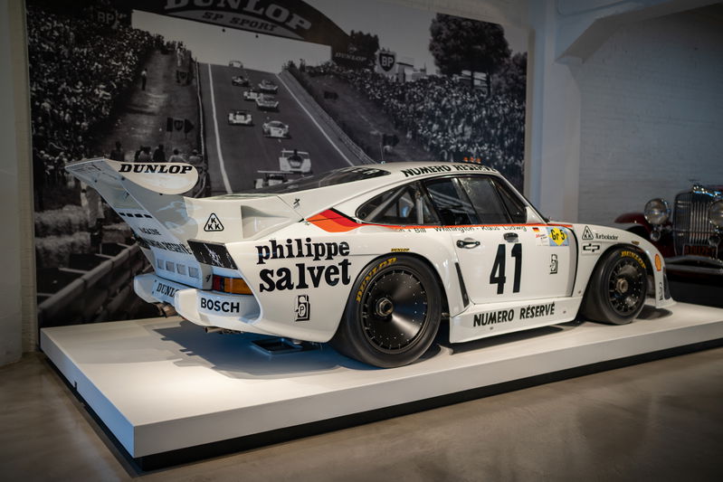 White 1979 Porsche 935 K3 race car with black rims and racing livery.