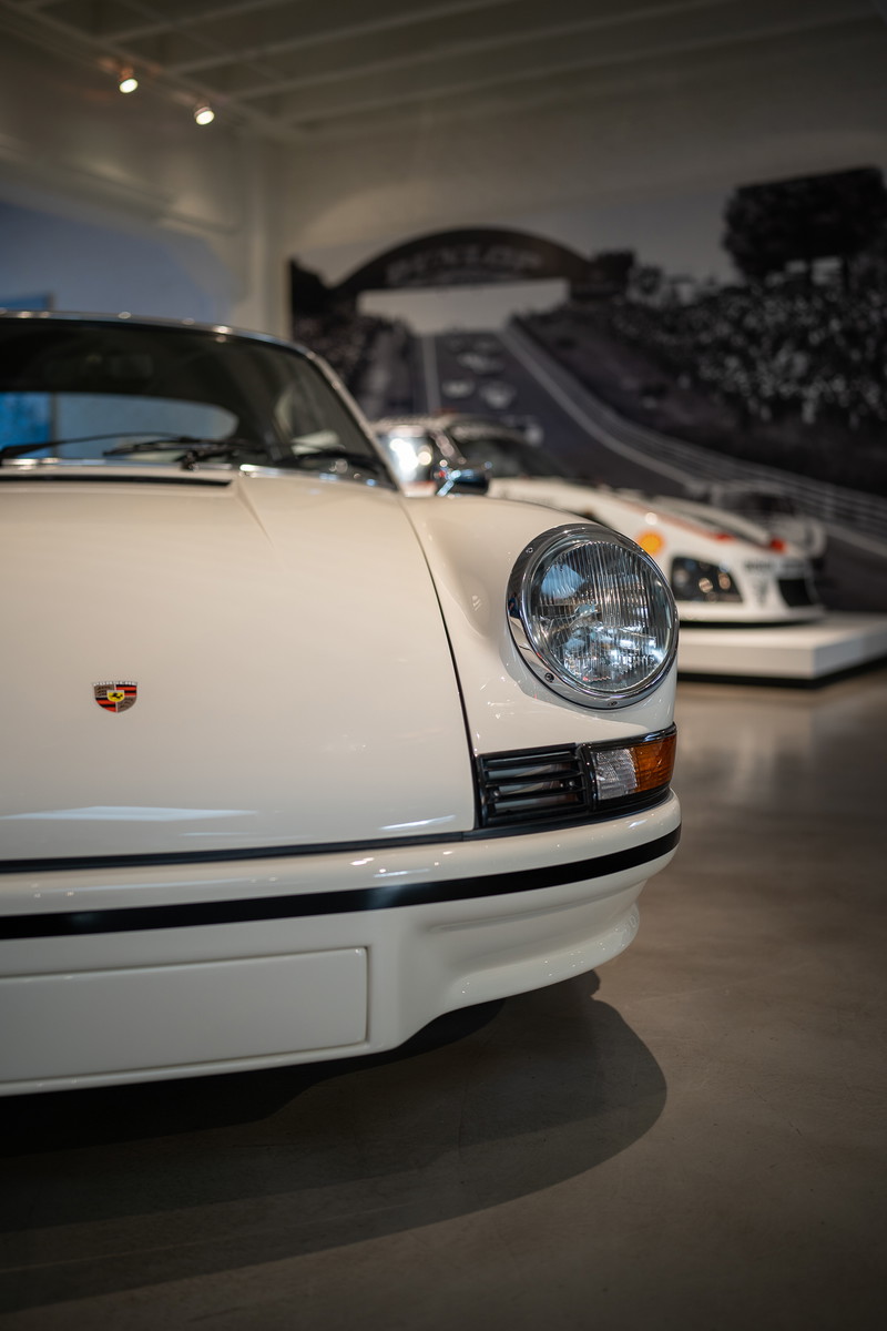 Close-up of a white Porsche 911 front fender with black trim.