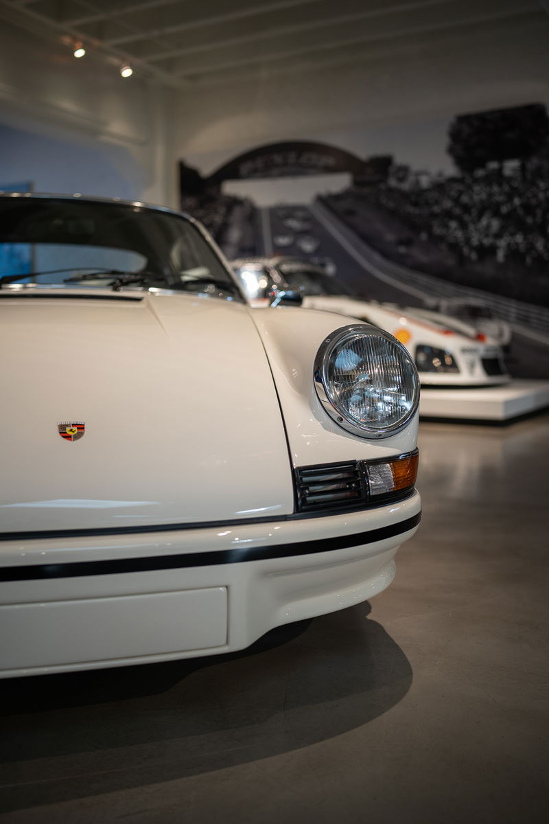 Close-up of a white Porsche 911 front fender with black trim.