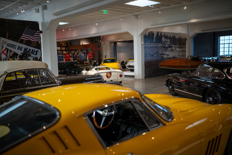 Close-up of a yellow 1967 Ferrari 275 GTB/4, interior detail, with other cars blurred.