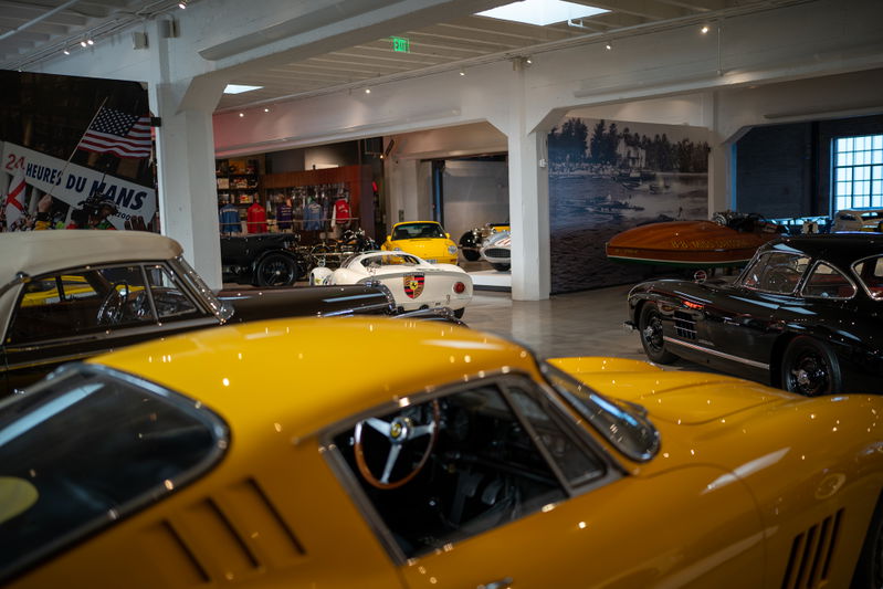 Close-up of a yellow 1967 Ferrari 275 GTB/4, interior detail, with other cars blurred.
