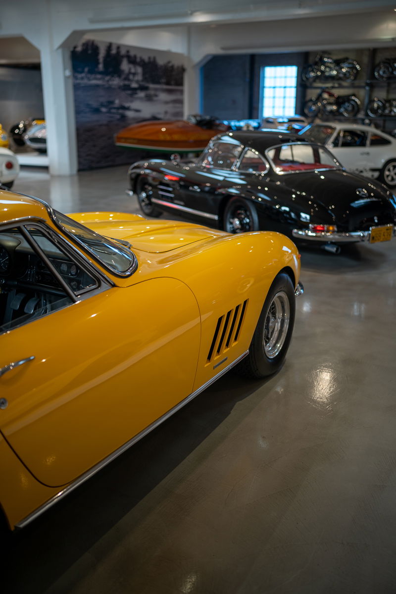 Close-up of a yellow Ferrari 275 GTB with chrome trim and classic rims.