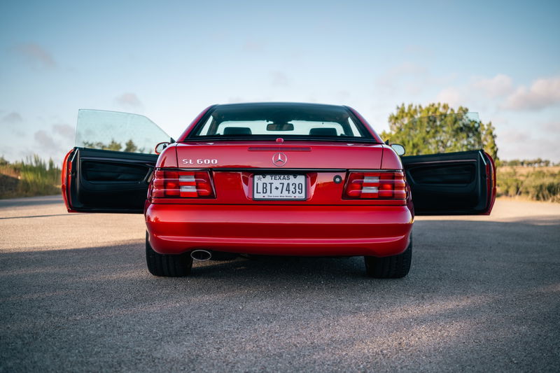 Rear view of a red 2001 Mercedes-Benz SL600 with doors open.