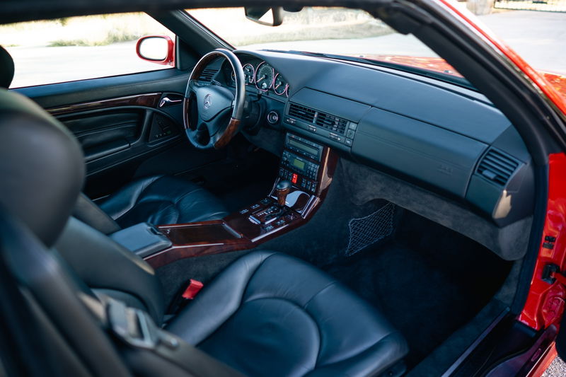 Interior of a red 2001 Mercedes-Benz SL600, featuring leather seats, wood trim, and a multimedia system.