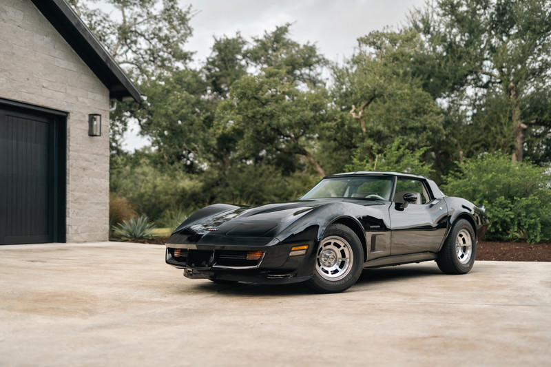 Black 1982 Chevrolet Corvette Stingray with factory alloy rims parked outdoors.