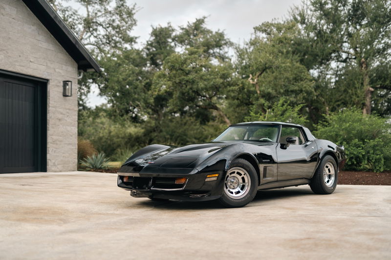 Black 1982 Chevrolet Corvette Stingray with factory alloy rims parked outdoors.