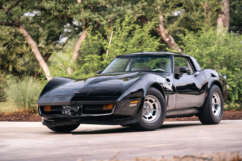 Black 1982 Chevrolet Corvette Stingray with silver rims parked outdoors.