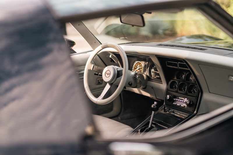 1982 Chevrolet Corvette Stingray interior, showing white steering wheel, dash, and center console.