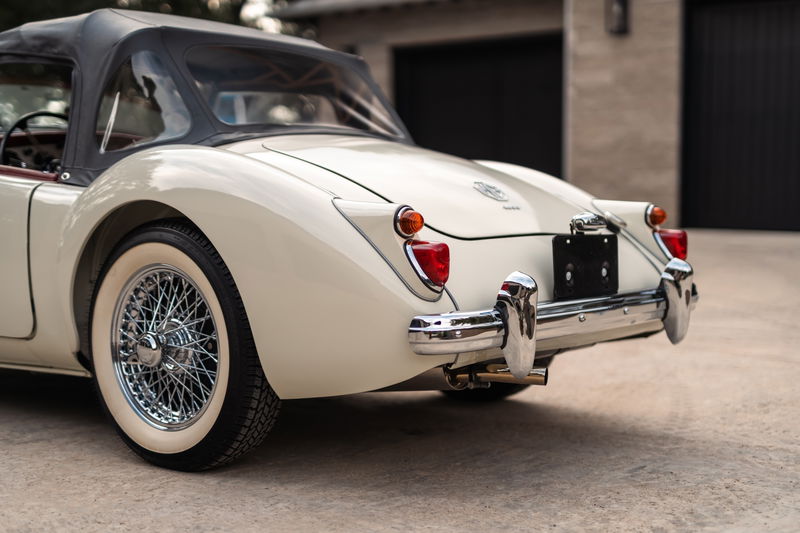 Cream 1957 MG MGA convertible rear view, showing wire rims and chrome bumper.