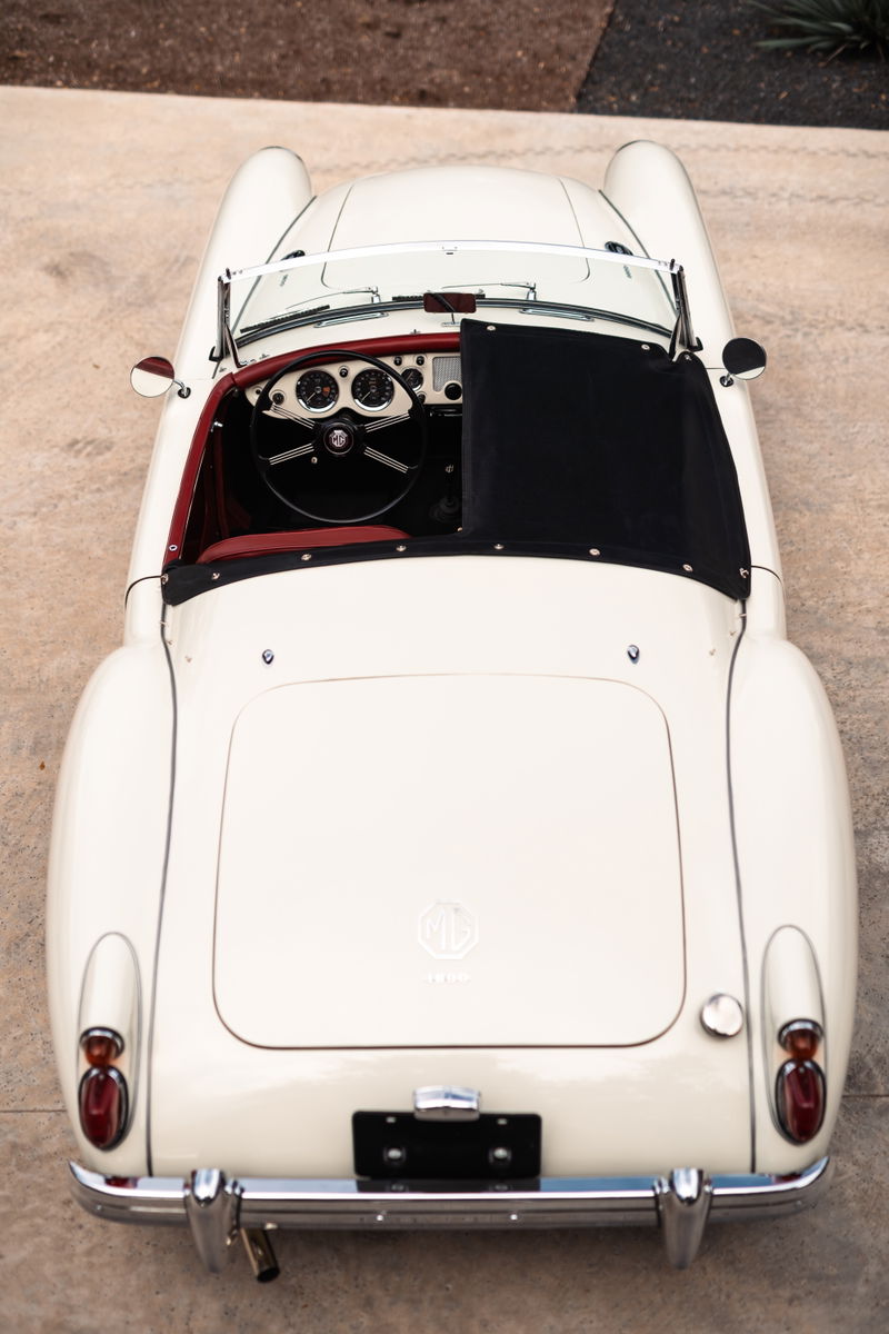 1957 MG MGA roadster in Old English White with red interior, viewed from above.