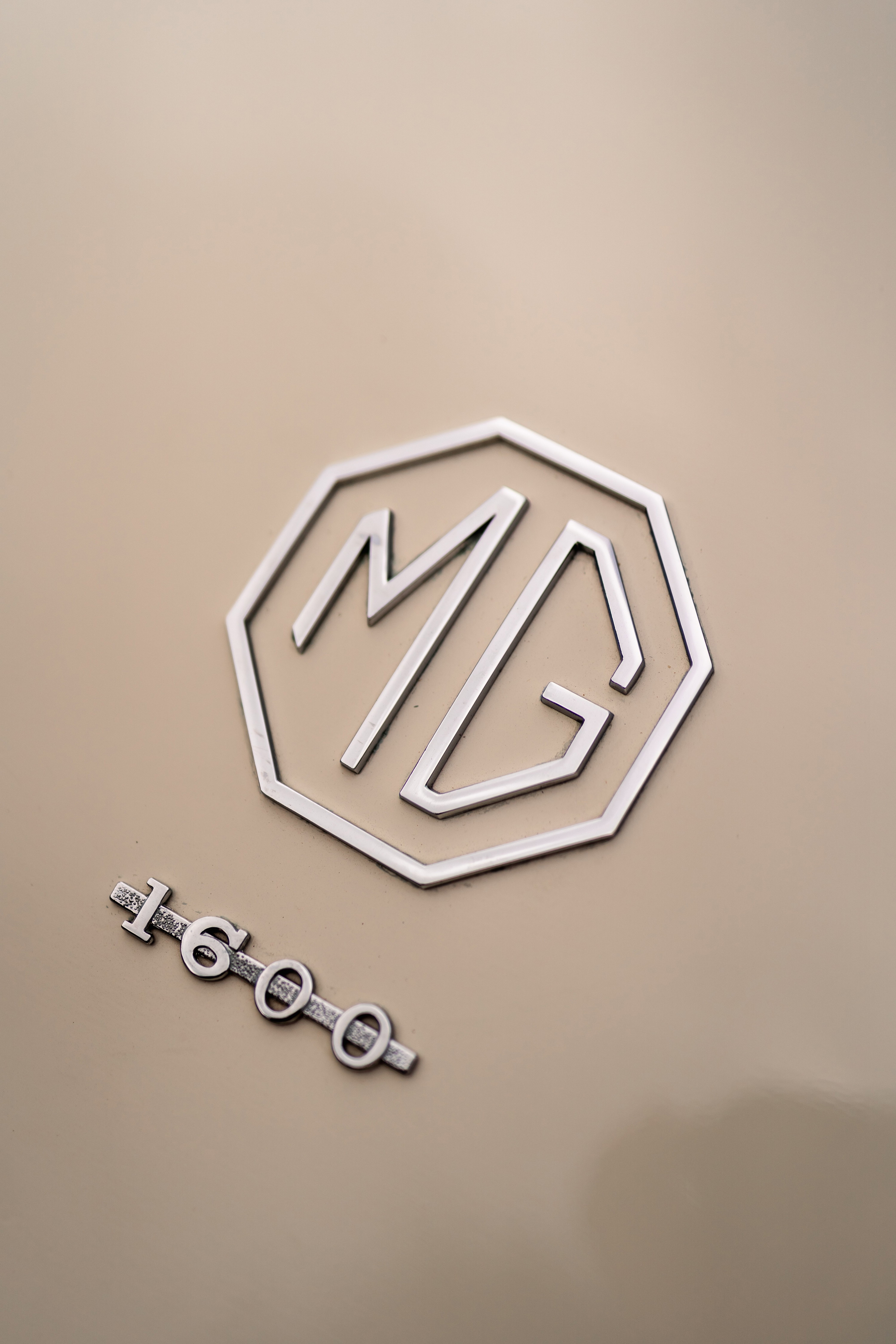 Chrome "MG" badge and "1600" trim on the Old English White 1957 MG MGA.