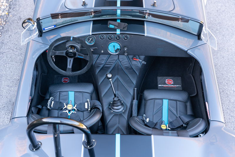 1965 Backdraft Cobra interior with racing seats, racing harnesses, and carbon fiber trim.