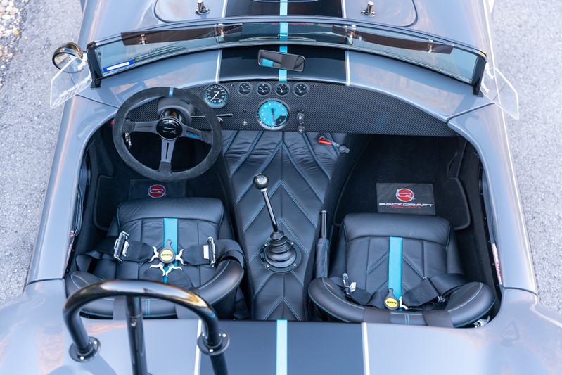 1965 Backdraft Cobra interior with racing seats, racing harnesses, and carbon fiber trim.
