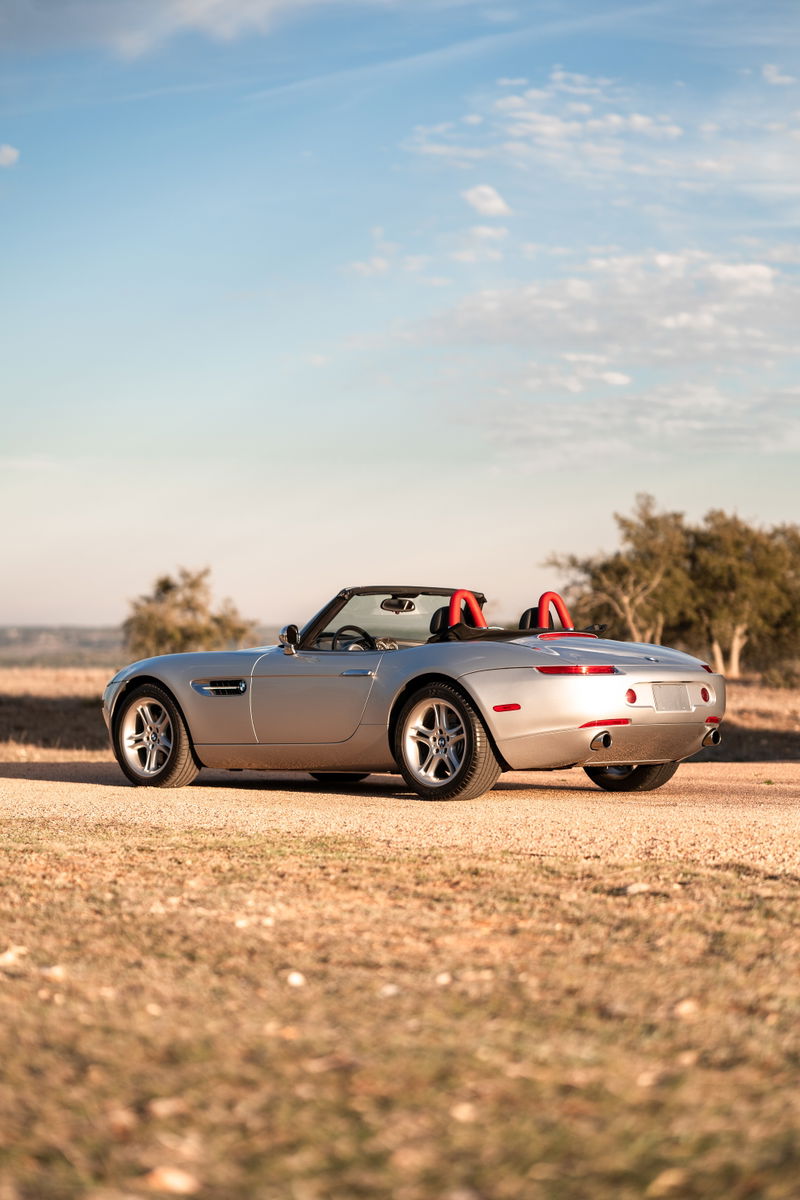 2002 BMW Z8 convertible in Titanium Silver with red roll hoops and multi-spoke rims.